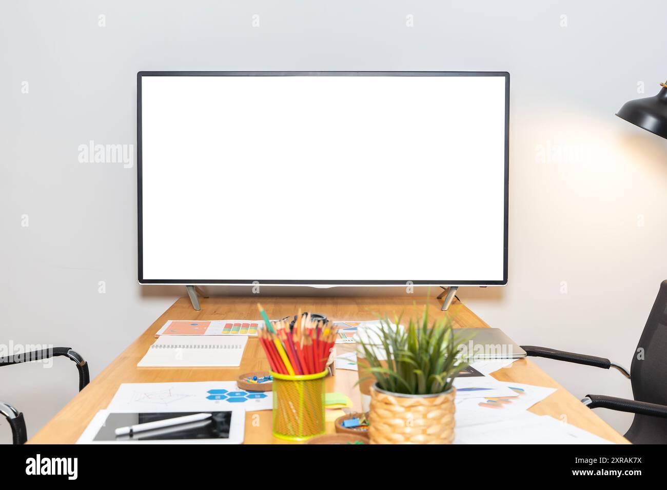 A blank white TV sits on a table in a meeting room. The room is clean and tidy, with no people or other distractions, suggesting that it is an importa Stock Photo