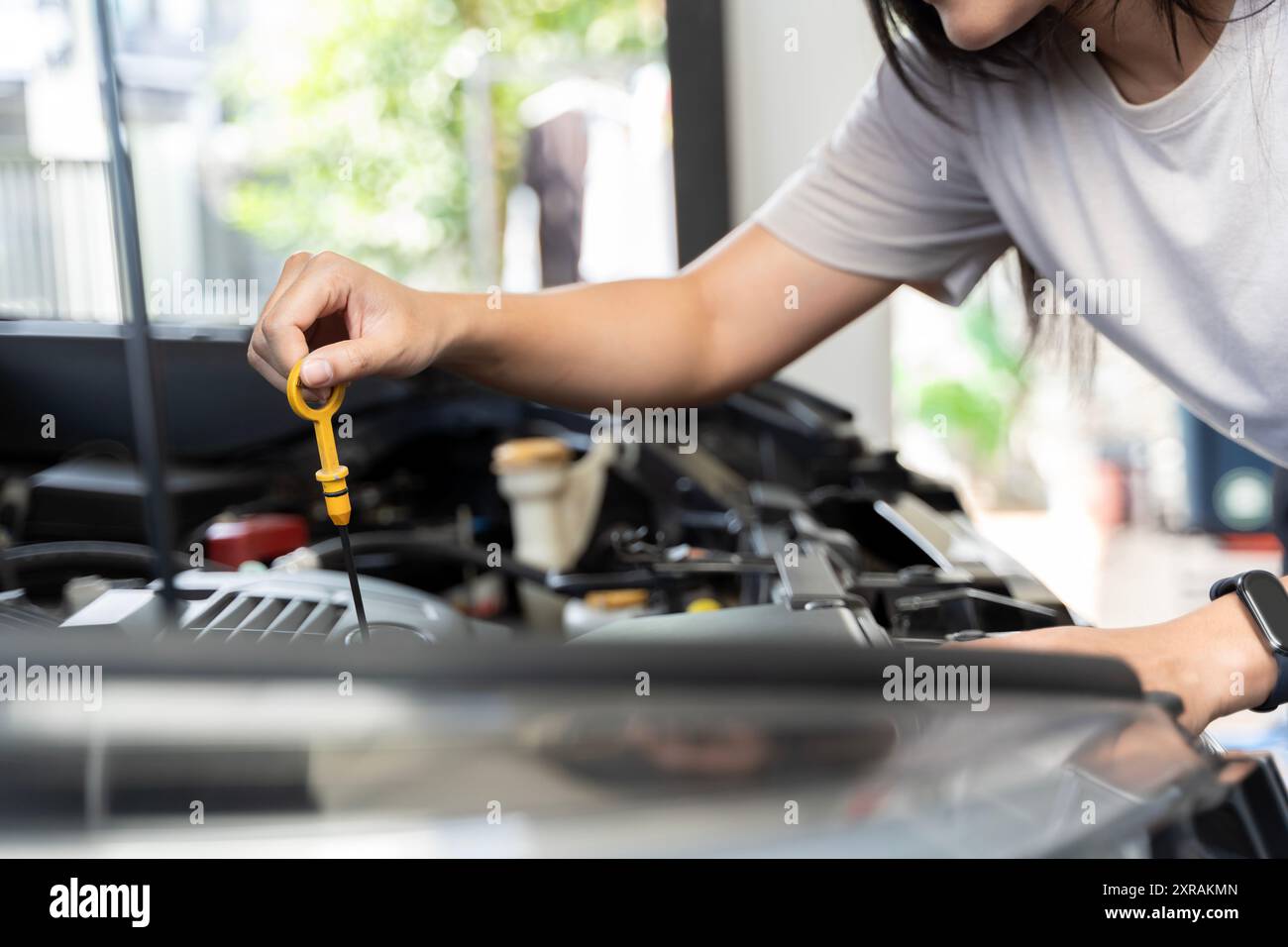 Close-up photo of woman's hand check engine oil A woman pulls out the ...