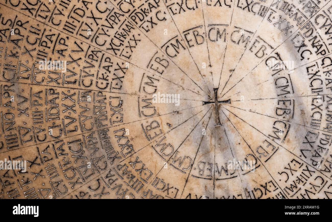 Close-up on ancient latin calendar carved in stone inside italian church Stock Photo