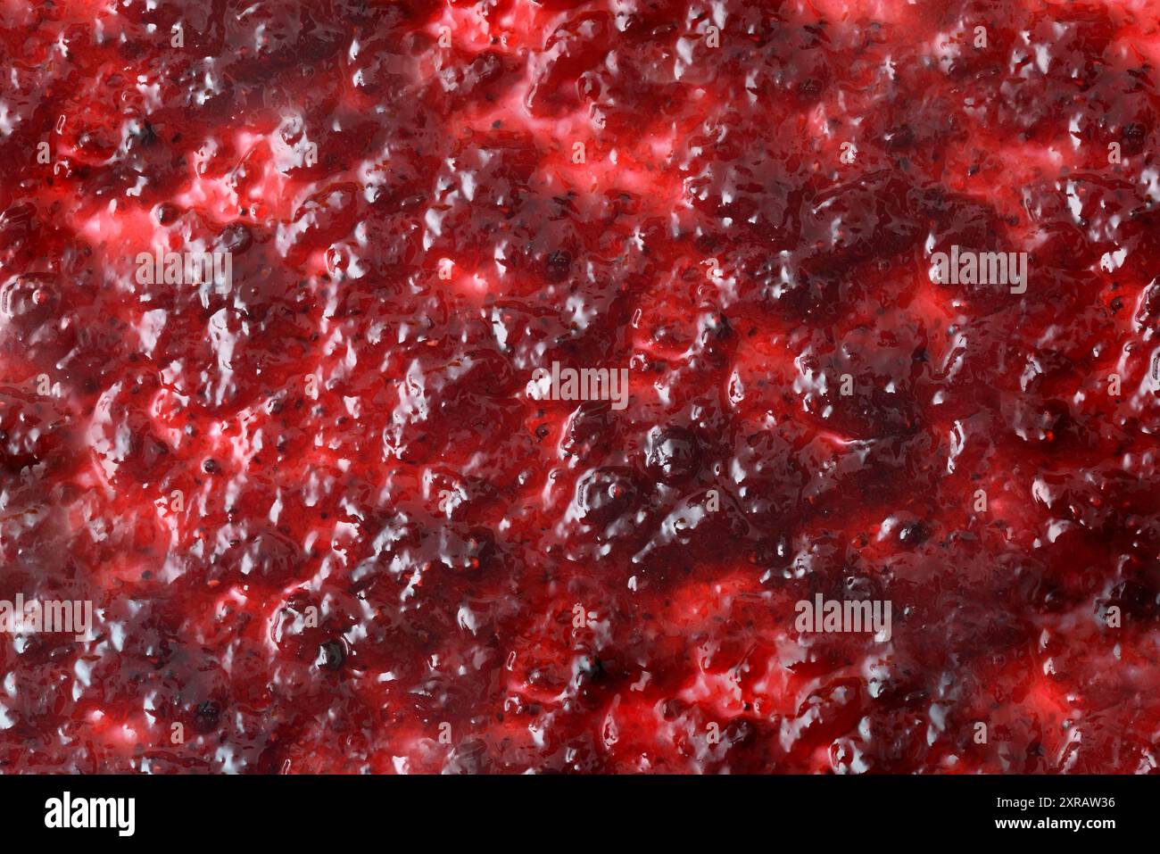 Background with forest fruit jam spread on a white base. Top view. Stock Photo