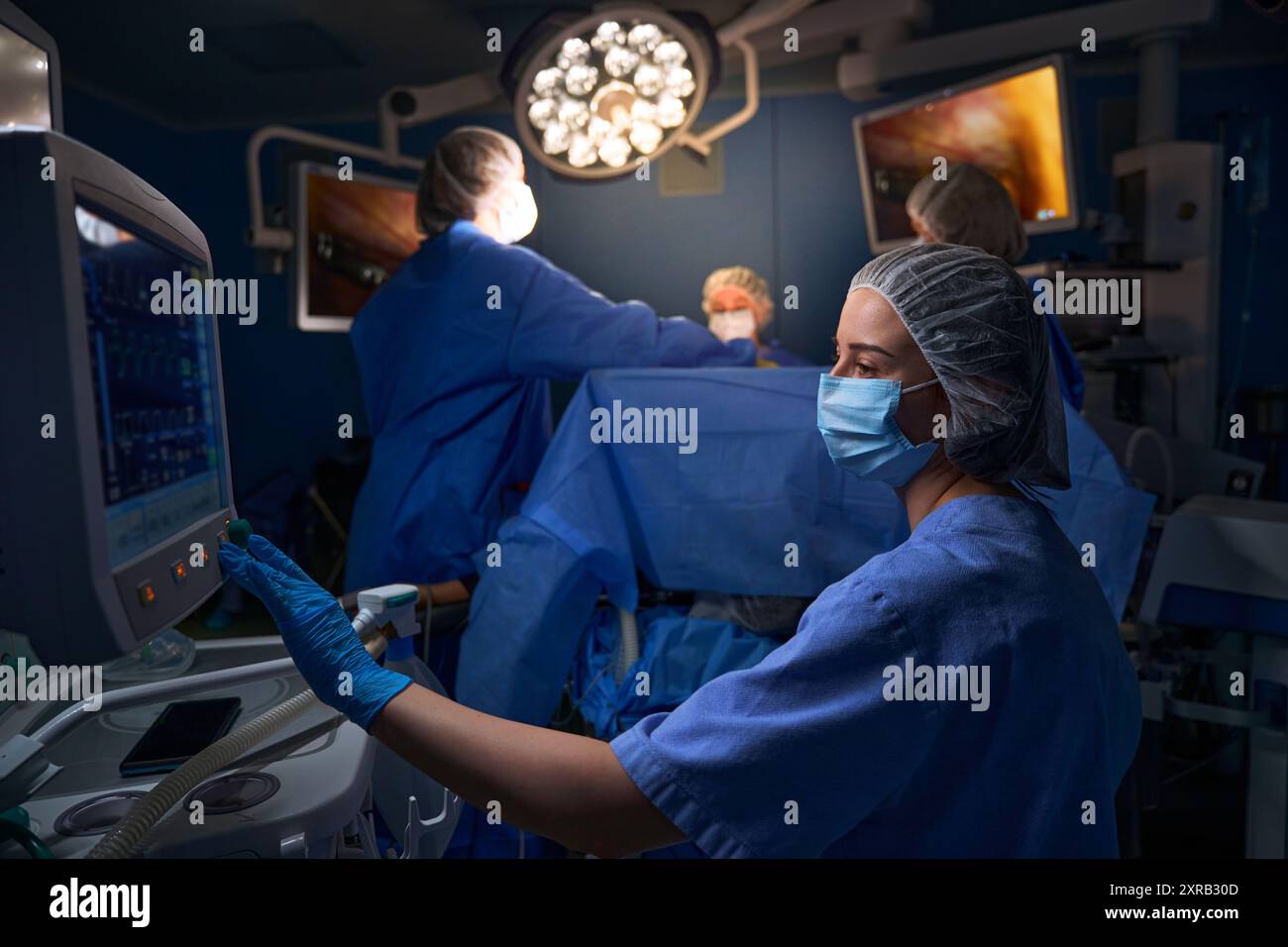 Surgeon Using Monitor Female surgeon looking at monitor in operating room Stock Photo - Alamy