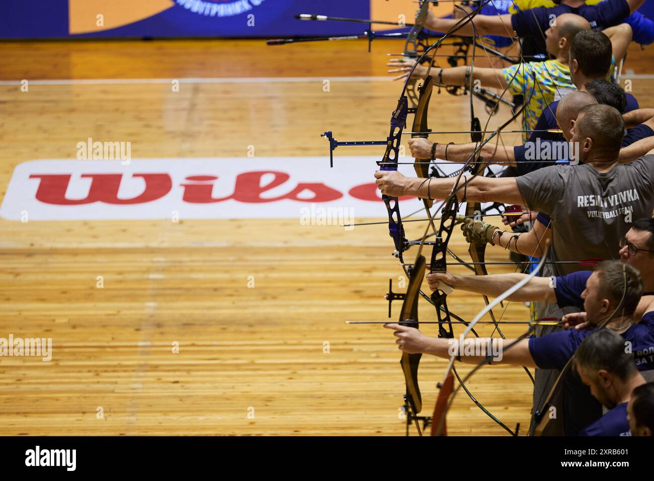 Group of archers with bows aiming the targets during arst archery competition. Kyiv - 14 December,2023 Stock Photo