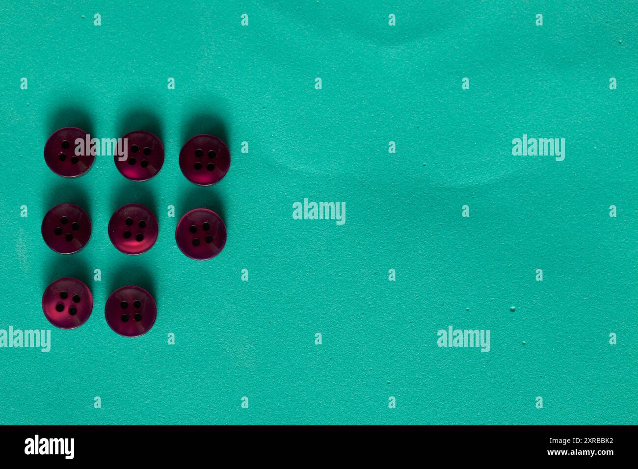 Buttons laid out in a row on a turquoise background. In the style of flat lay. Stock Photo