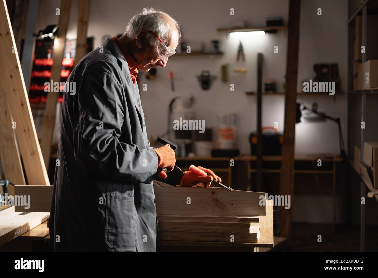 Carpenter working with wood plank using chisel and hammer Stock Photo ...