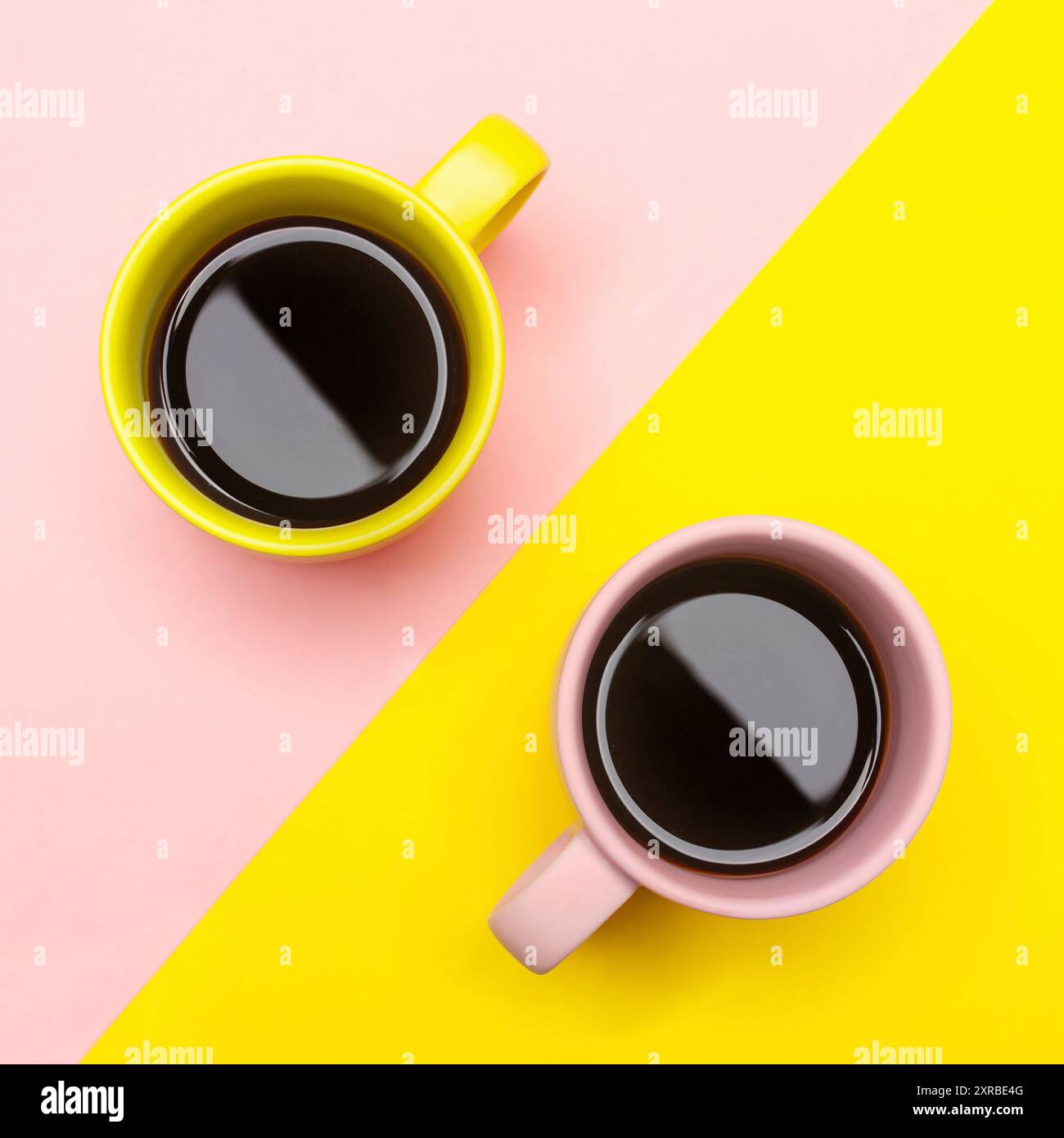 Flat lay top view of a two coffee cups with pink and yellow. Stock Photo