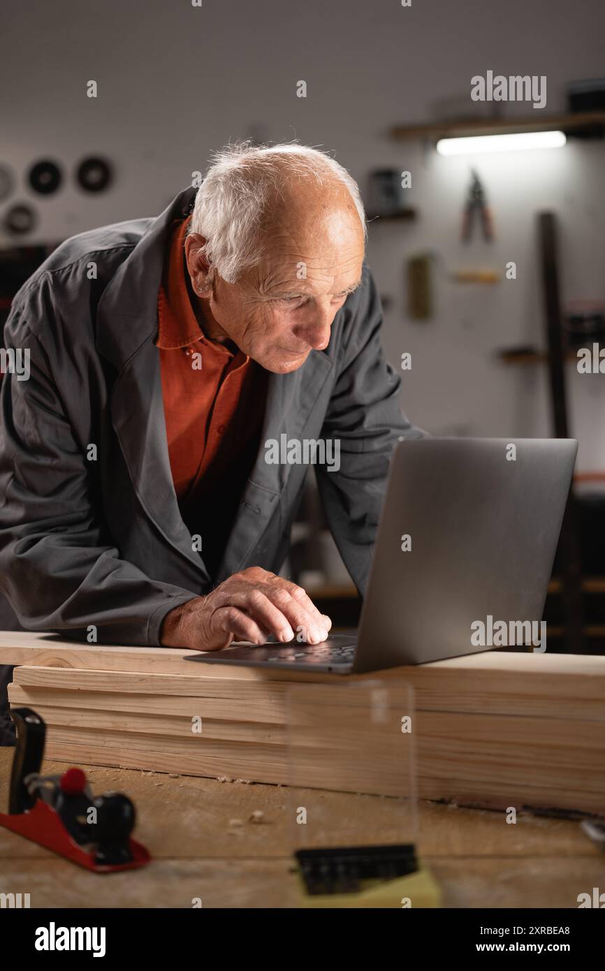 Smiling craftsman using laptop hi-res stock photography and images - Alamy