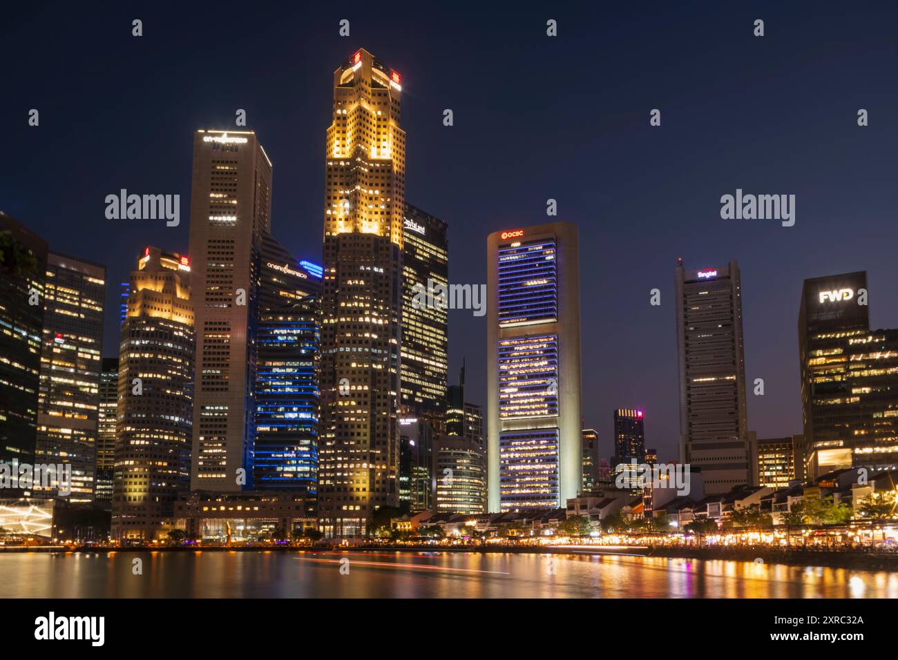 Asia, Singapore, Boat Quay and Singapore River with Riverside Pubs and Restaurants and City Business Area Buildings at Dusk Stock Photo