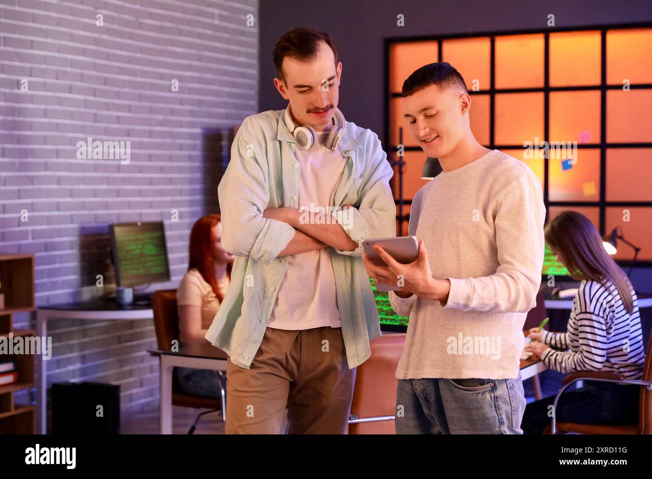 Male programmer with tablet computer in office at night Stock Photo