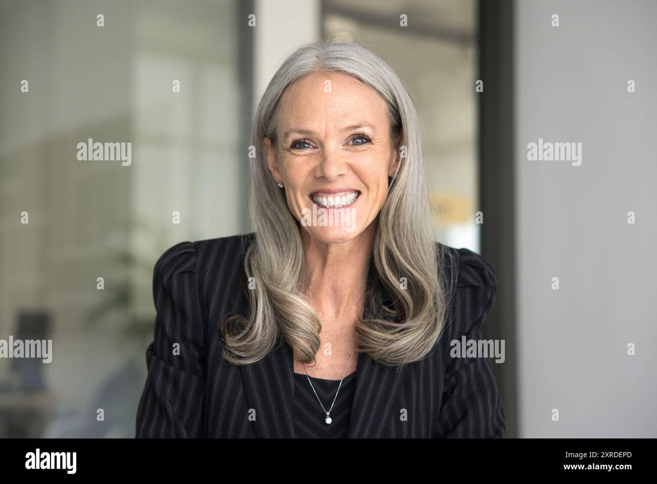 Happy senior executive lady in formal cloth looking at camera Stock Photo