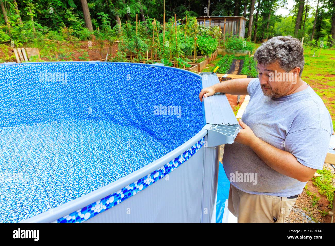 Assembling of ground swimming pool near house in back yard as part of ...