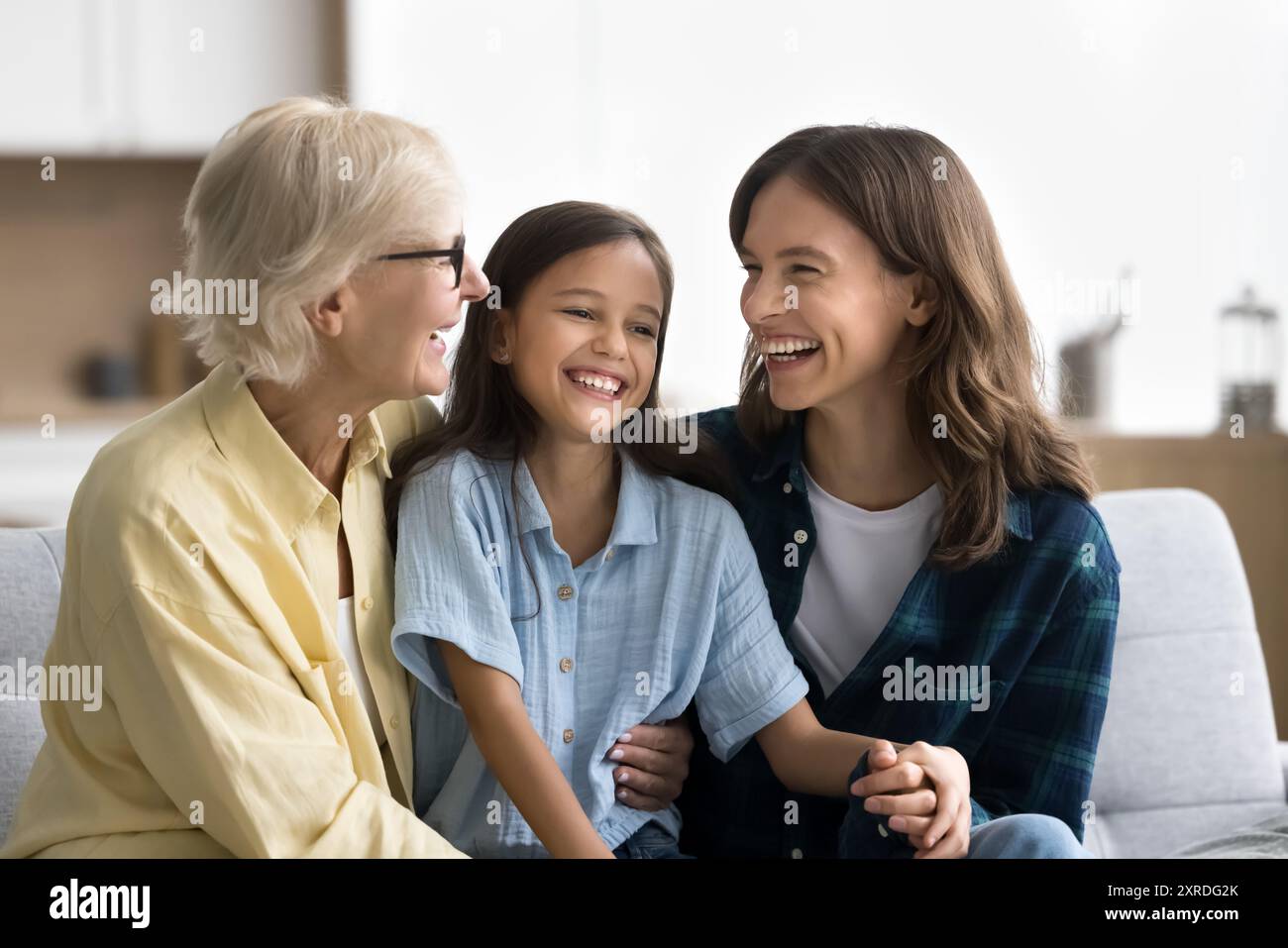 Joyful young mom and senior grandma cuddling kid girl Stock Photo - Alamy