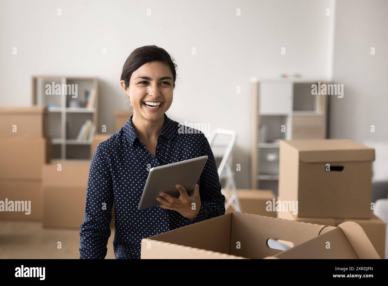Happy Indian businesswoman using tablet working in warehouse Stock Photo