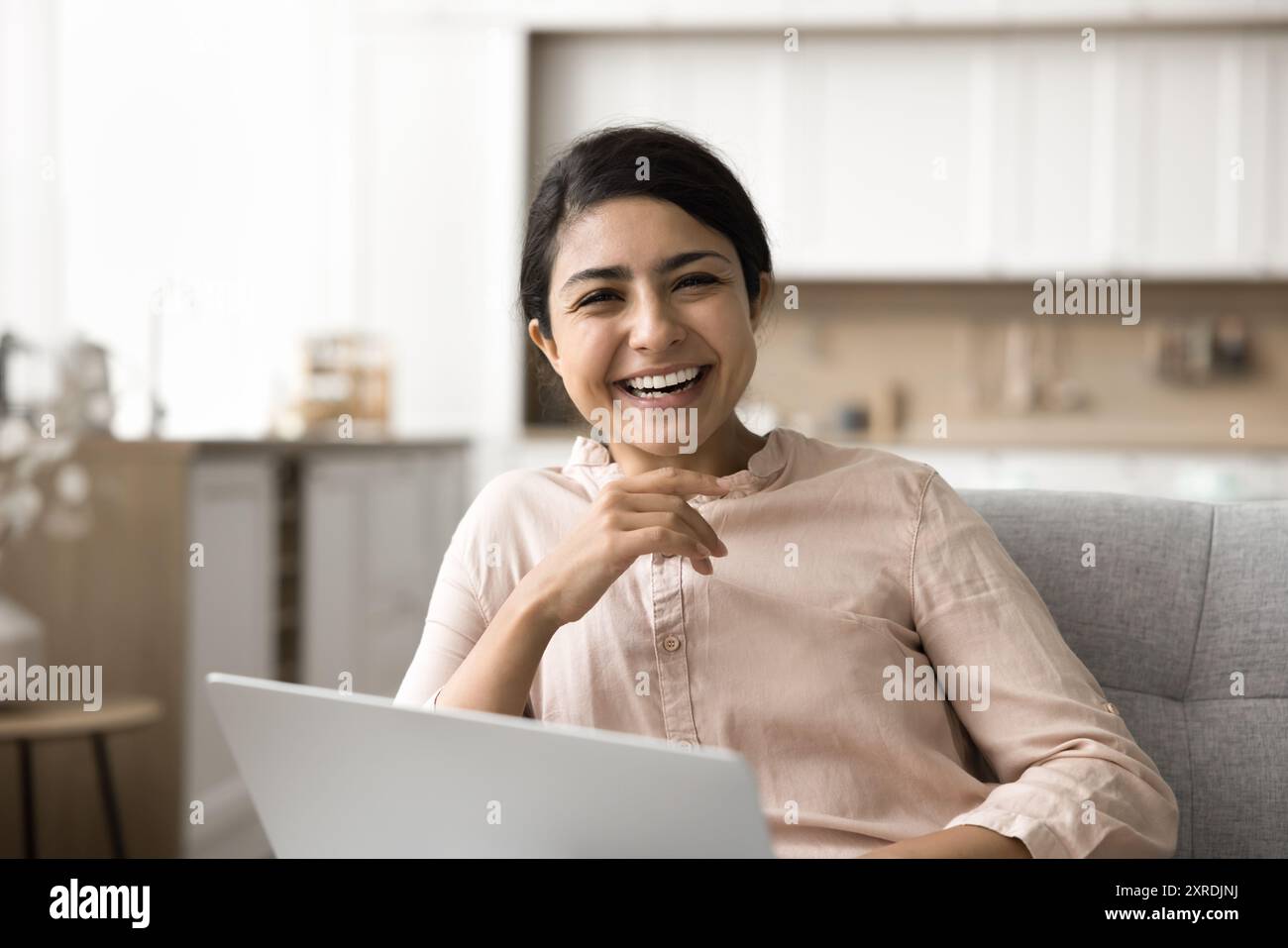Woman sit on sofa with laptop laughing look at camera Stock Photo - Alamy