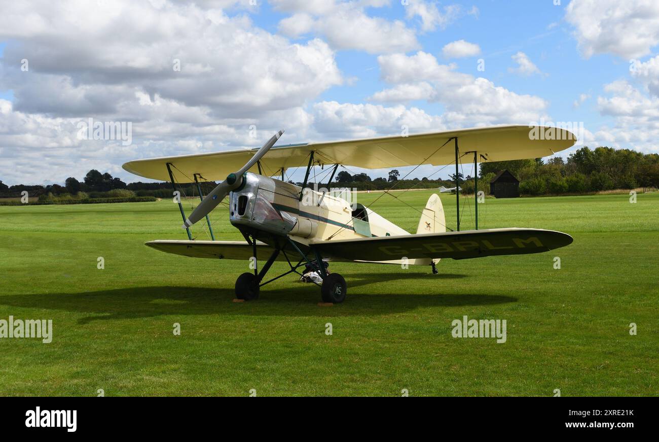 Vintage Stampe  SV.4C, G-HJSS  1101  Biplane  on airstrip grass with blue sky and clouds. Stock Photo