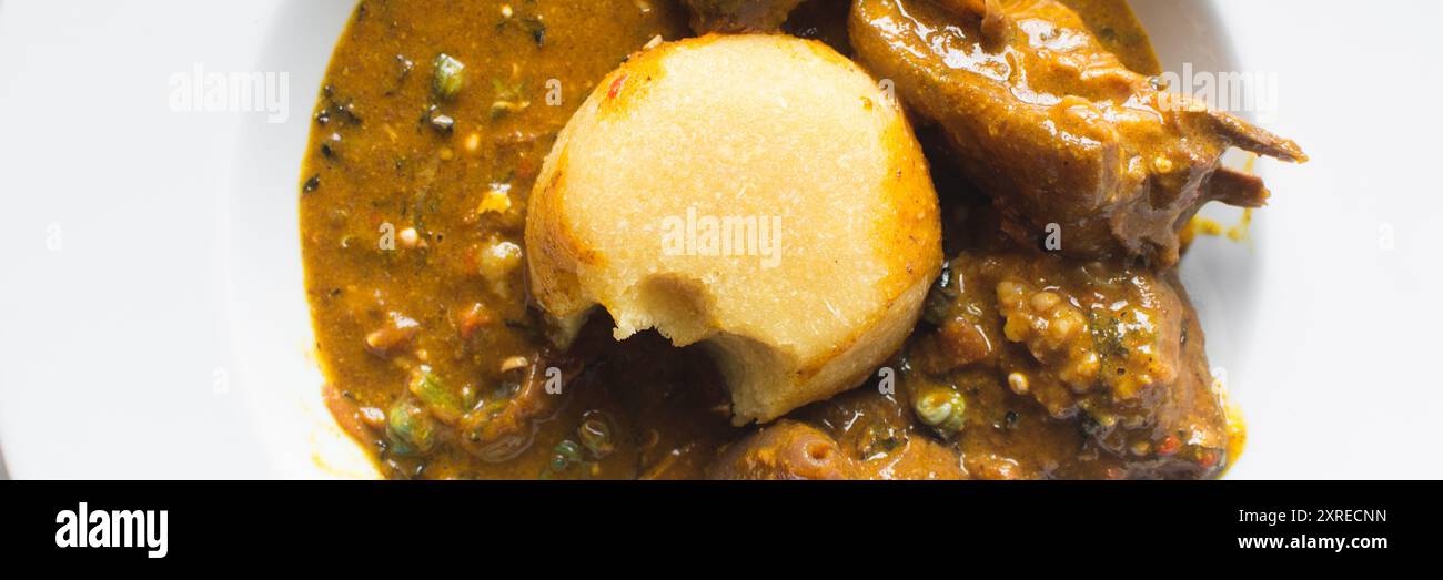 Overhead view of nigerian ogbono soup and eba on a white plate, top ...