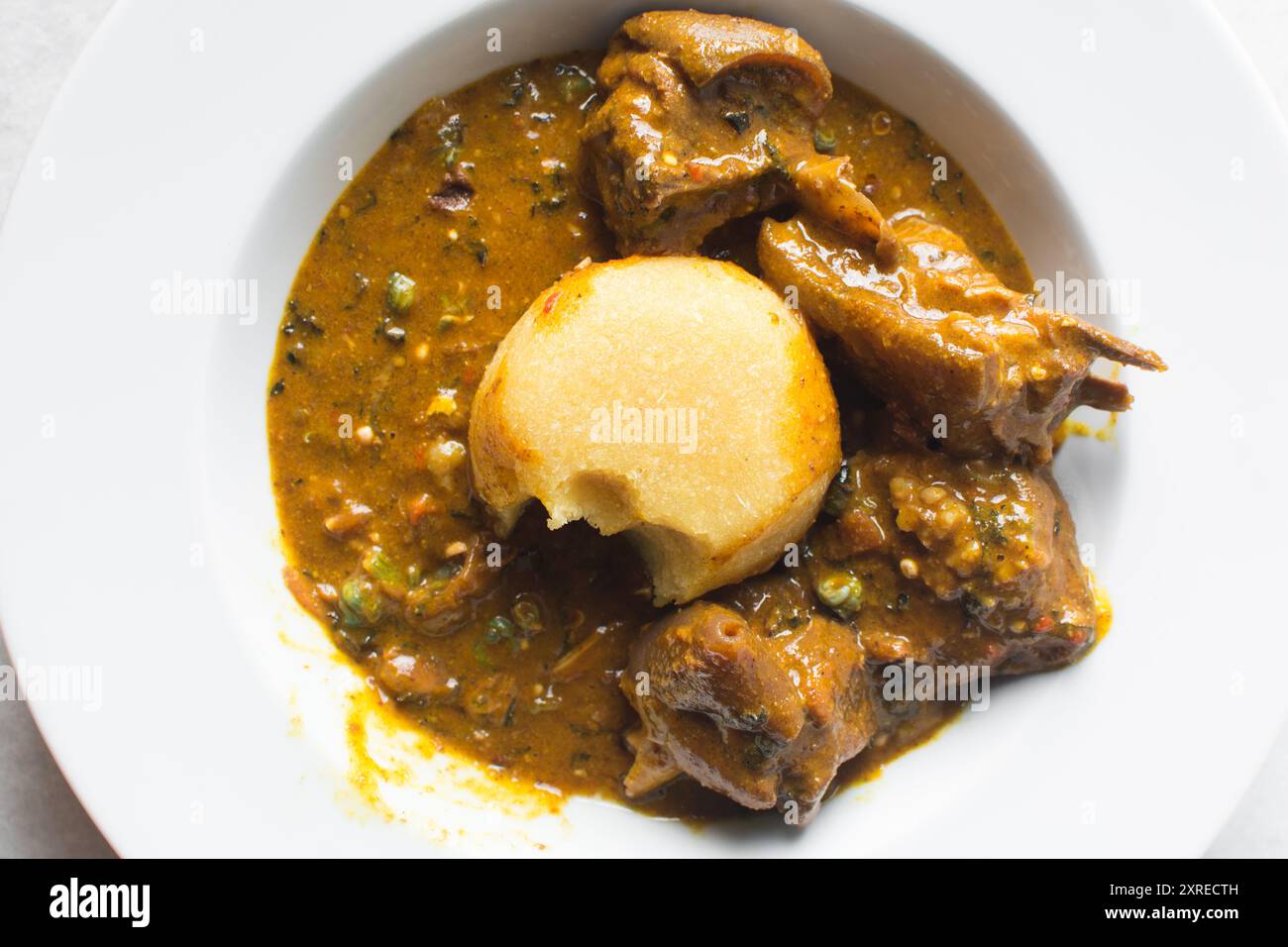 Overhead view of nigerian ogbono soup and eba on a white plate, top ...