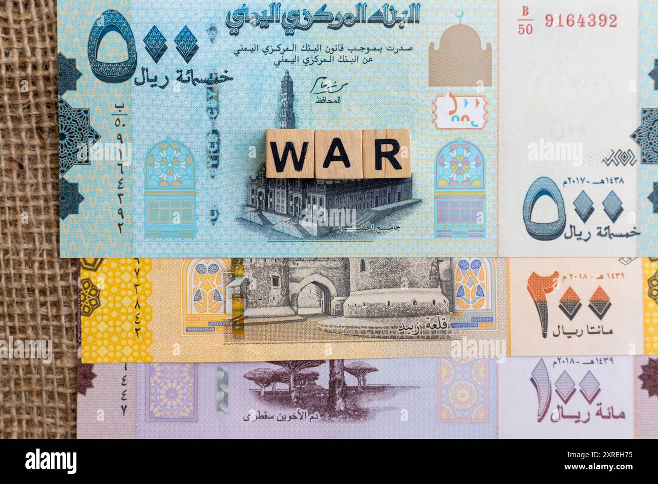 WAR on wooden cube blocks on Yemen rial banknotes Stock Photo