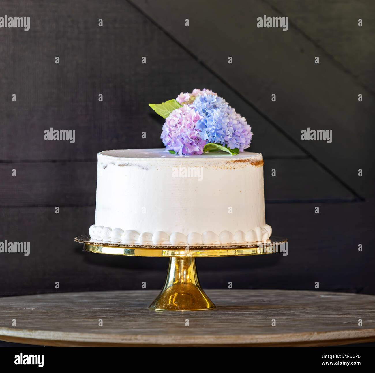 beautiful white birthday cake with fresh flowers against a background Stock Photo