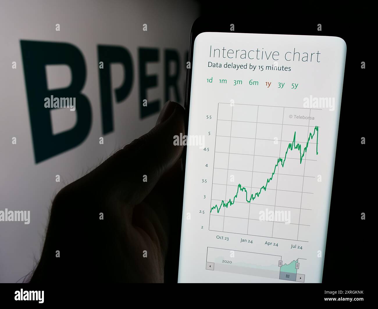 Person holding cellphone with website of Italian financial services company BPER Banca S.p.A. in front of logo. Focus on center of phone display. Stock Photo