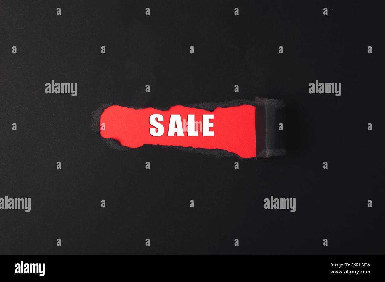 Sence In/sign A red sign with the word Sale written on it. The sign is torn in half ...
