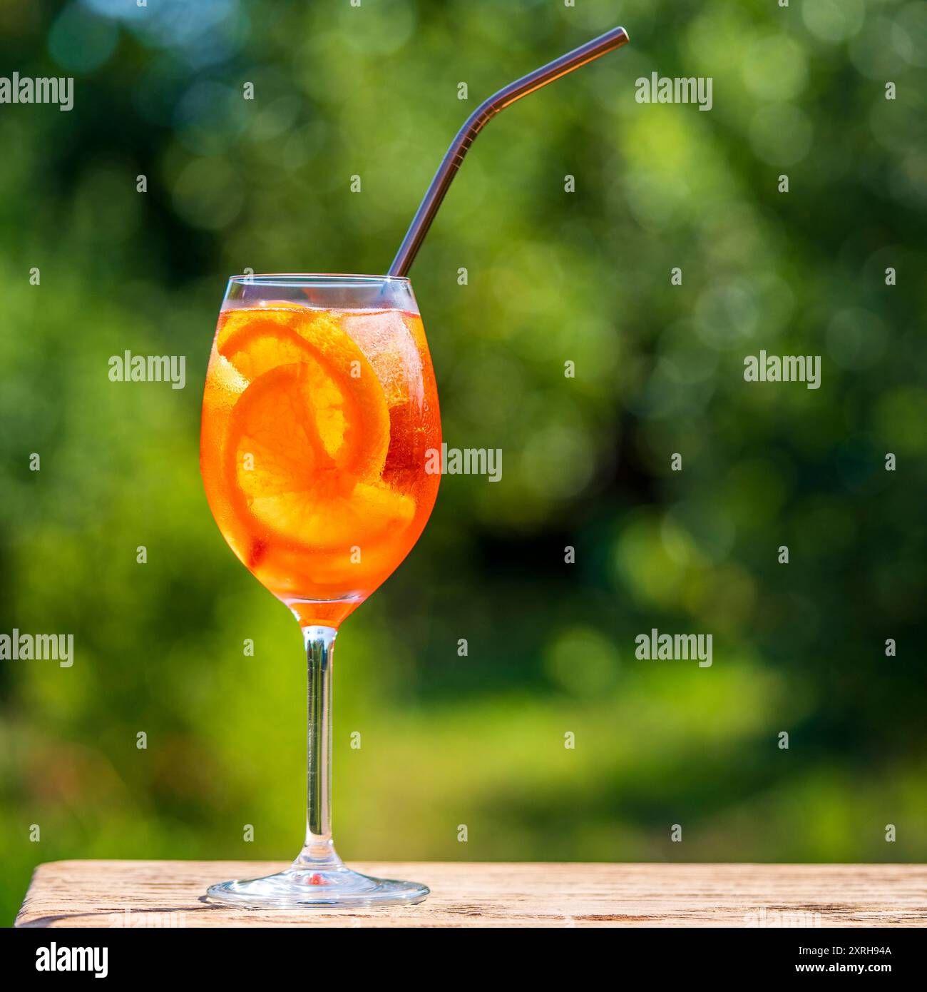 Aperol spritz cocktail in wine glass on a nature background. Classic