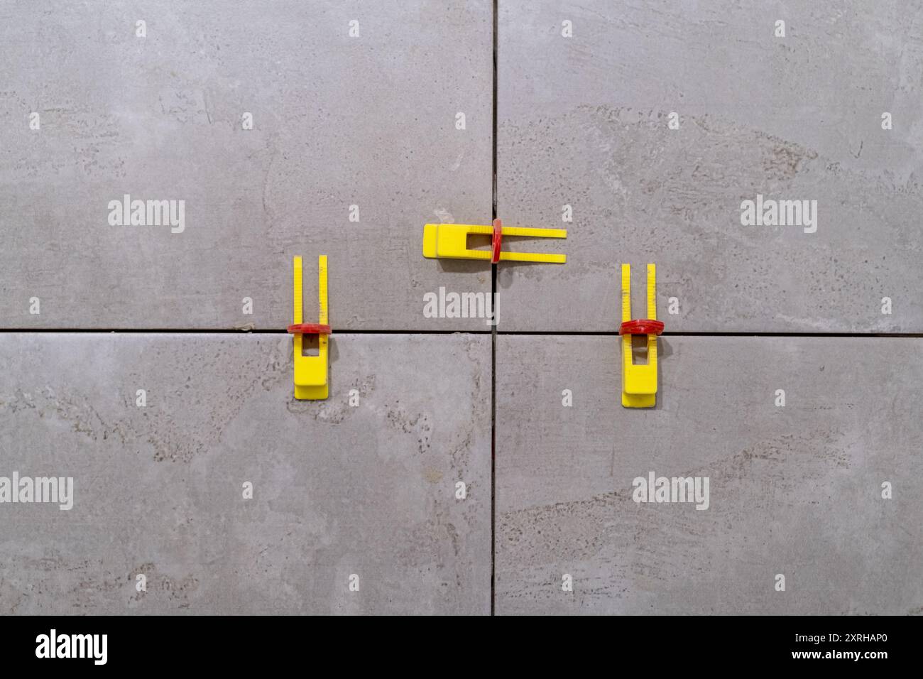 Tile leveling system with plastic clips and wedges in action. Ensures precise Stock Photo