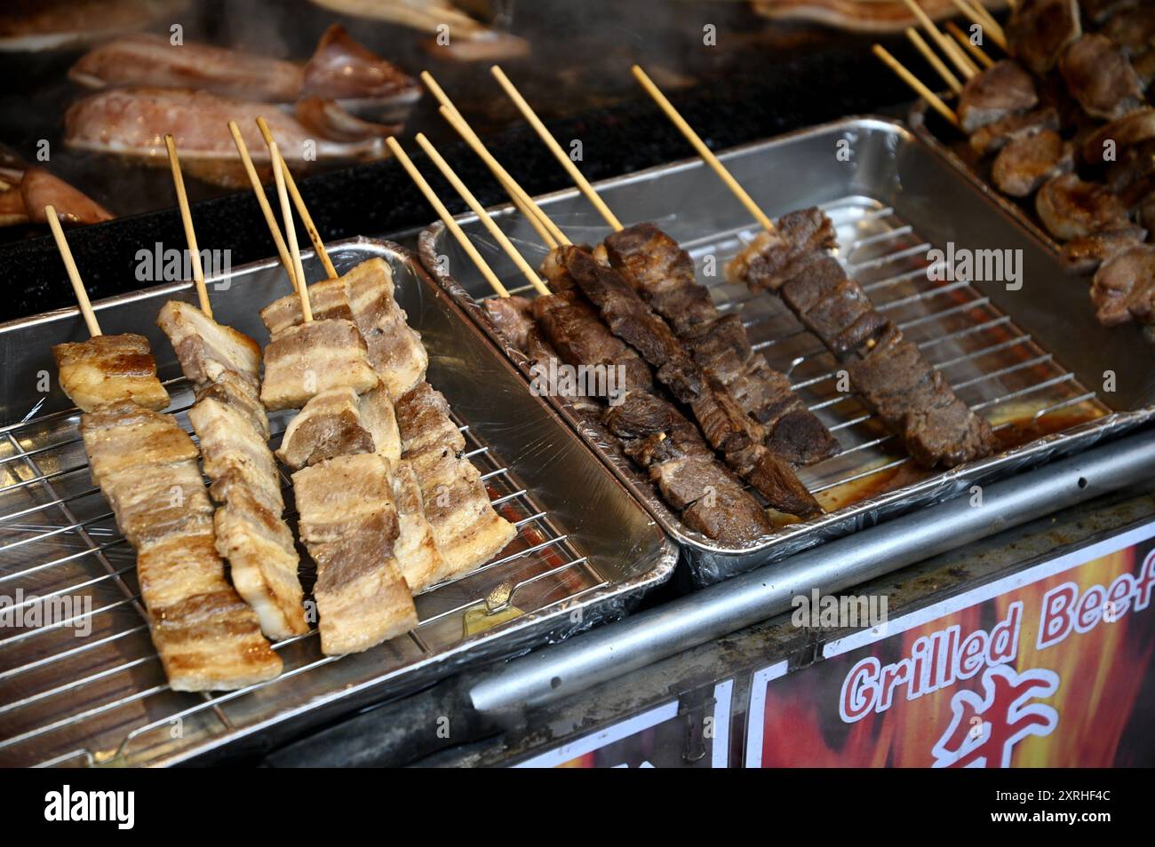 Street food stand display with chicken and wagyu beef skewers in ...