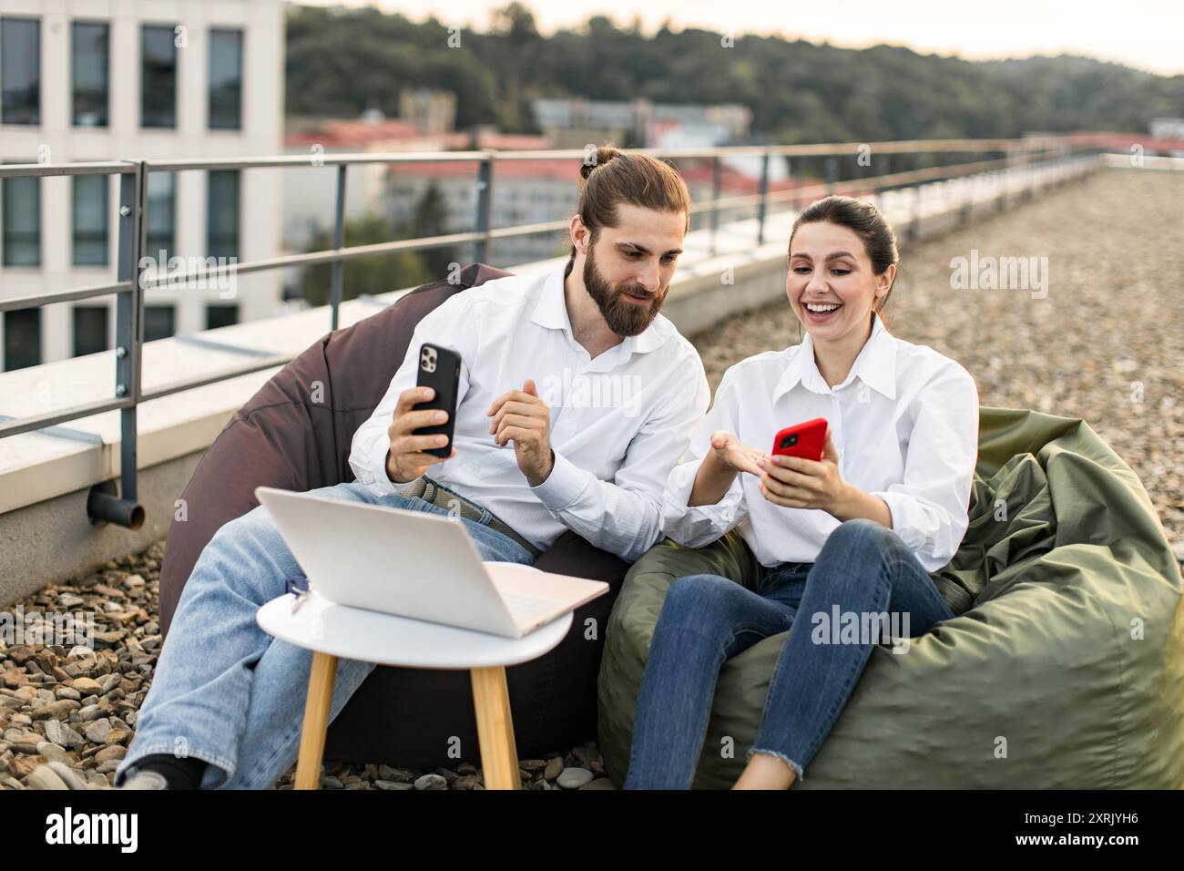 Young professionals working on rooftop with digital devices Stock Photo
