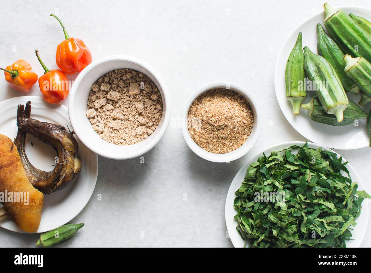 Overhead view of ingredients for making ogbono soup on a granite countertop, top view of mise en place of ingredients for making ogbono and okro soup, Stock Photo