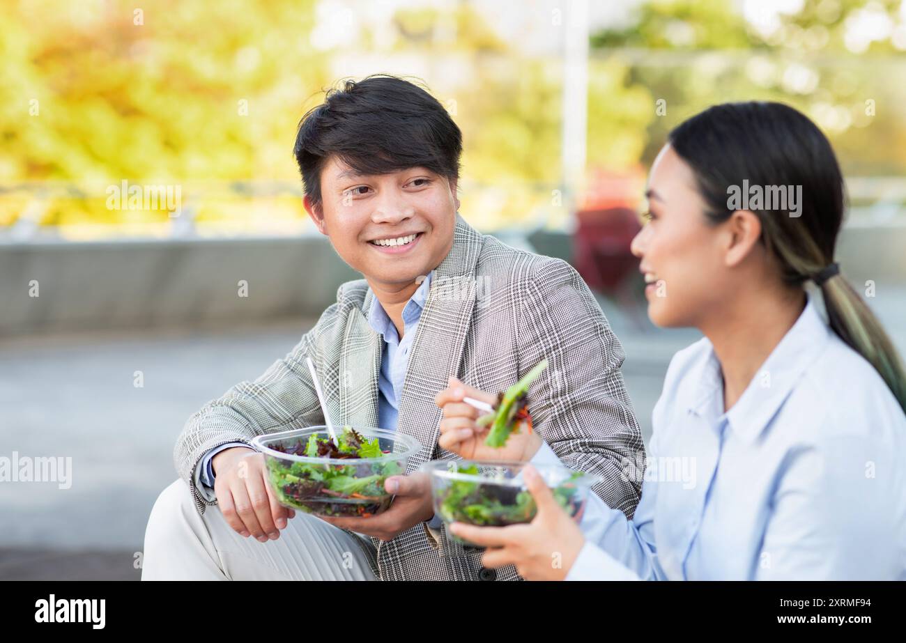 Young Friends Enjoying Fresh Salads At Outdoor Park During Afternoon ...