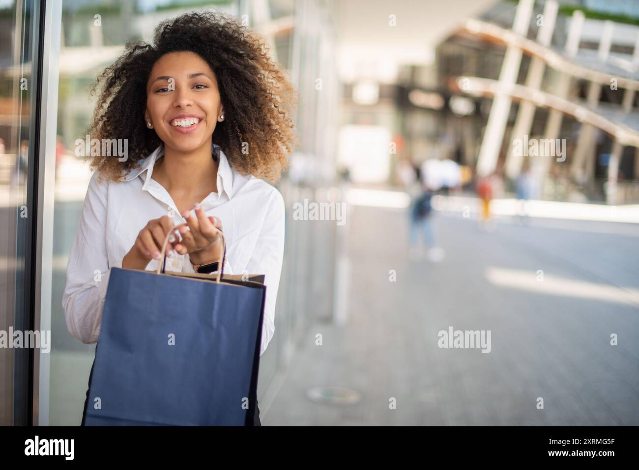 Young smiling black woman holding shopping bags Stock Photo - Alamy