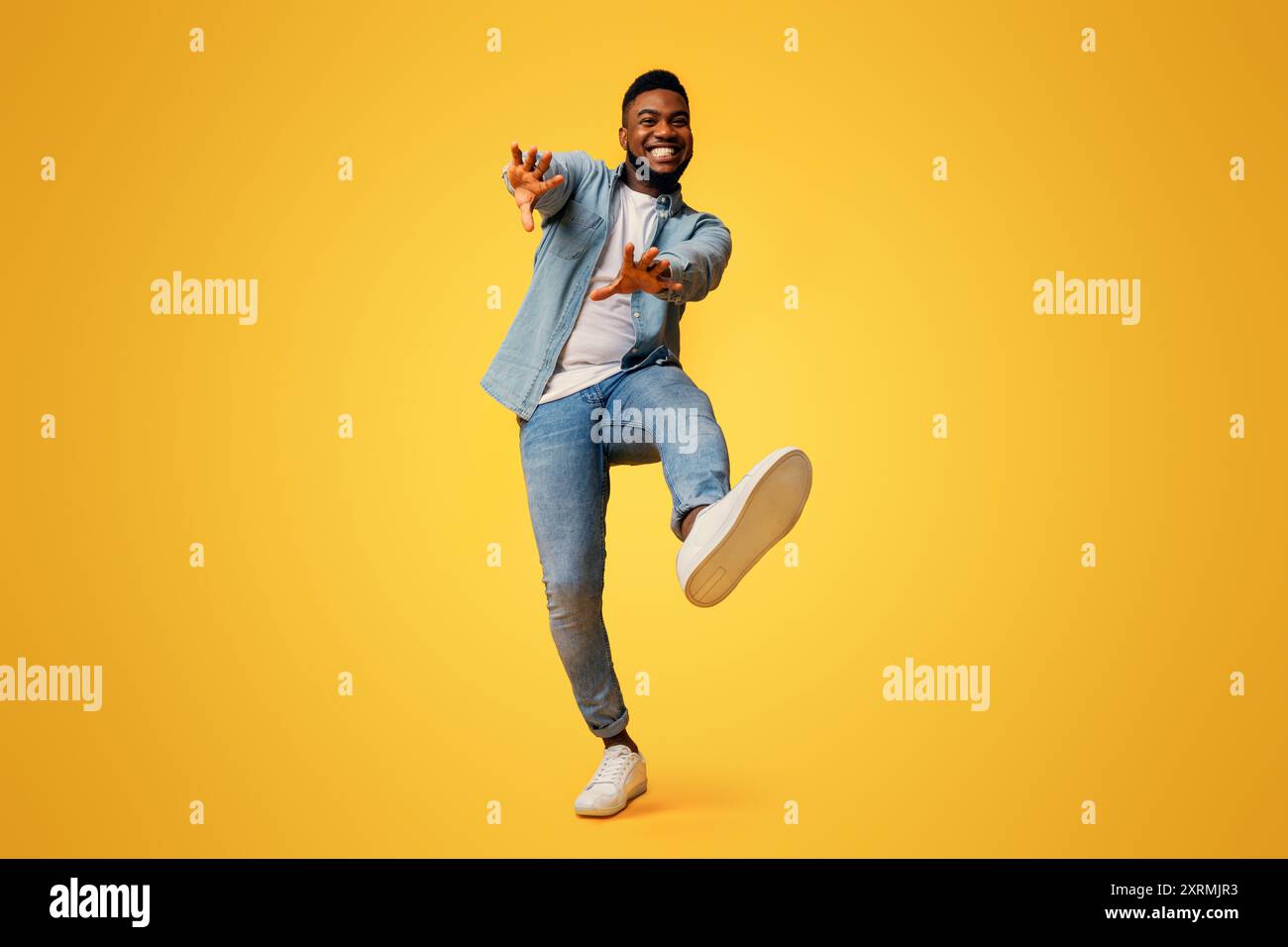 Funny black man dancing and extending his hands to camera Stock Photo