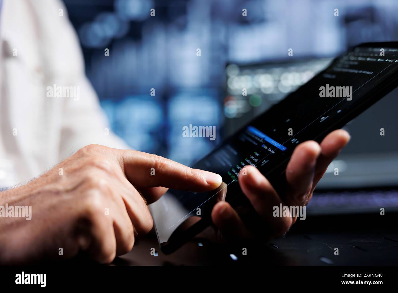System administrator coding in data center using javascript language, close up. Competent manager updating software on server rigs on tablet terminal, ensuring optimal performance and security Stock Photo