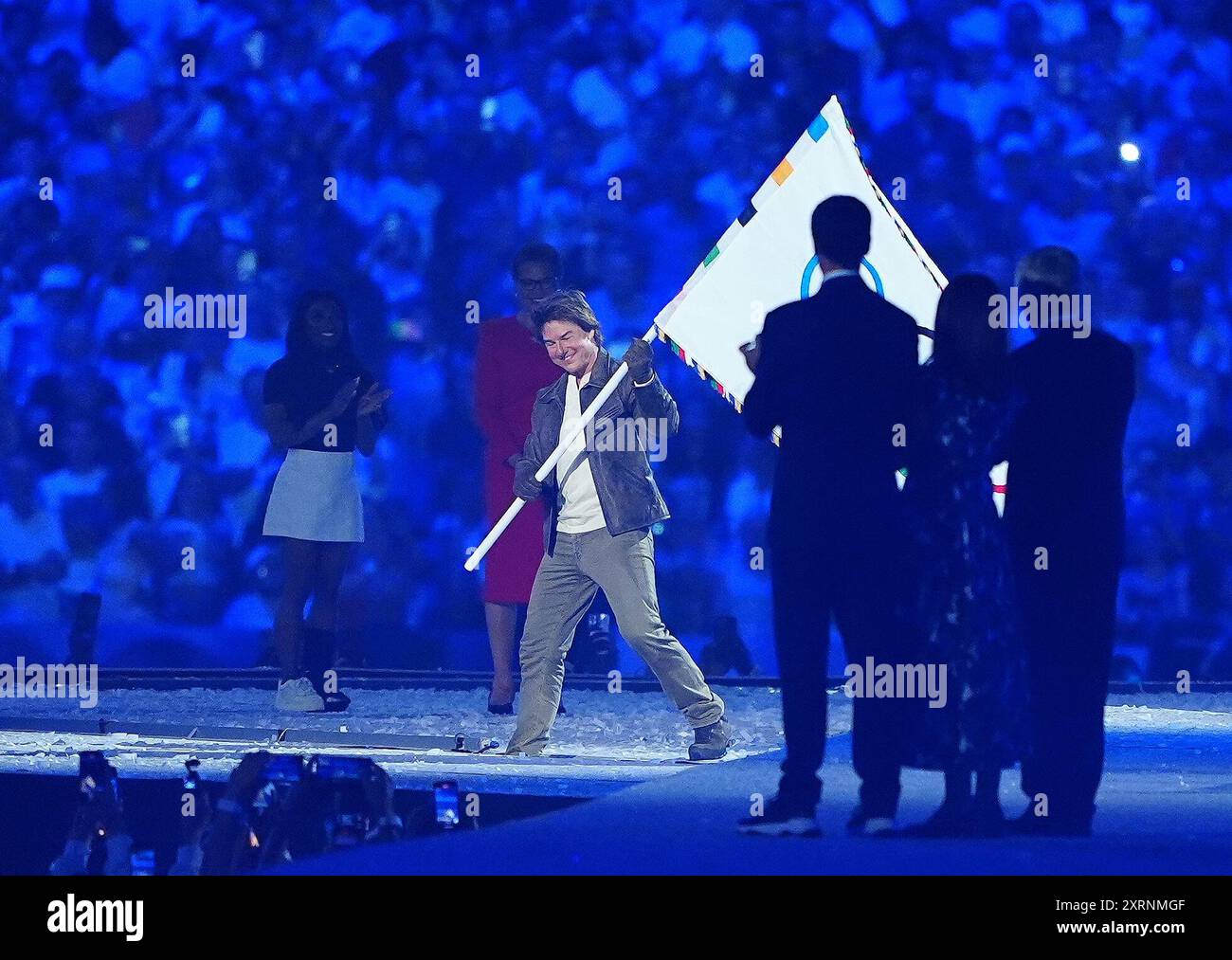 Tom Cruise takes the Olympic flag during the closing ceremony of the