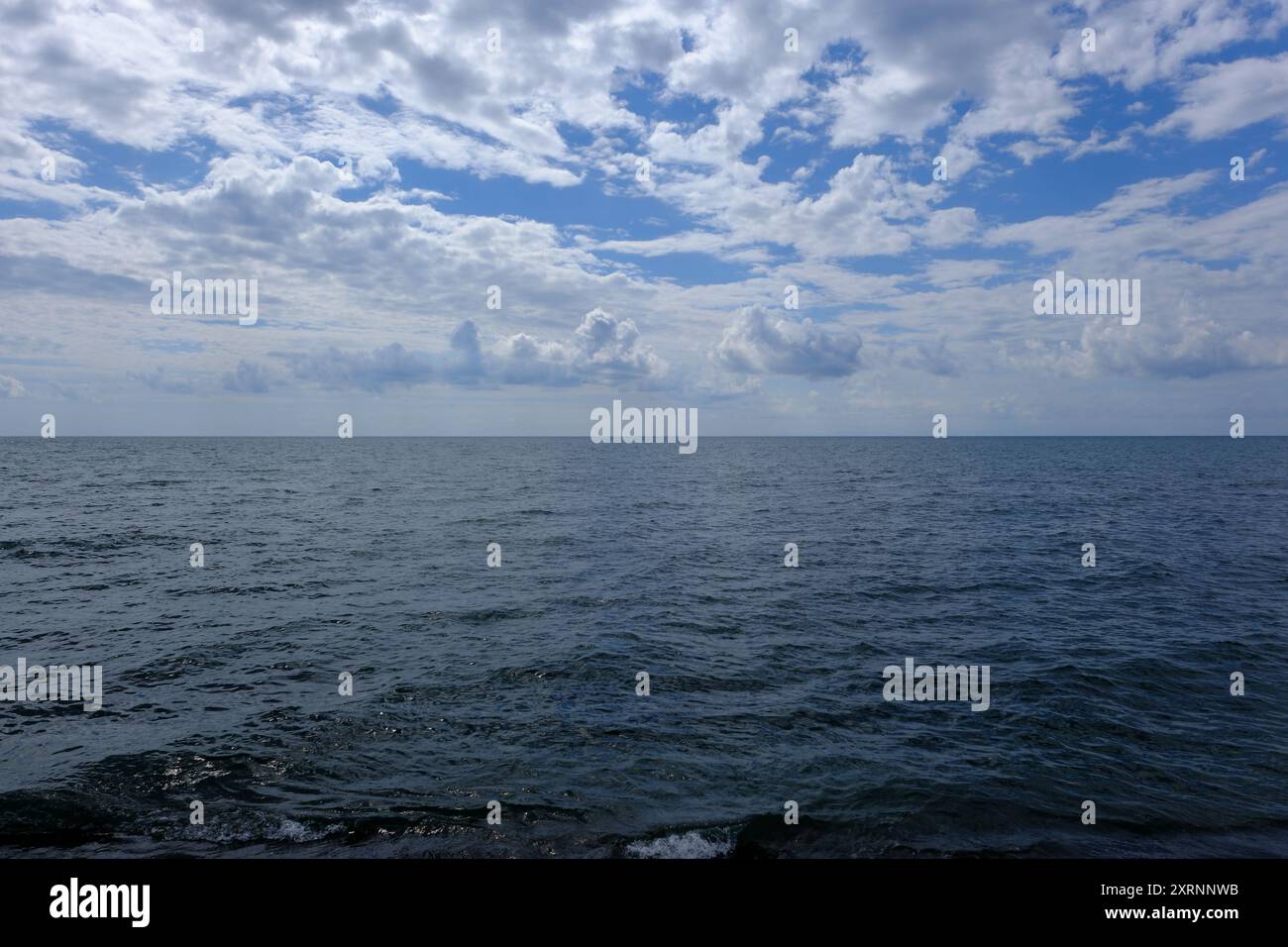 blue sky and white clouds over the sea surface. Beautiful seascape ...