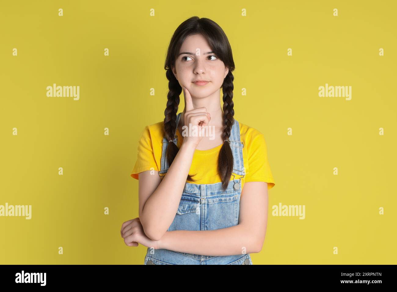 Portrait of cute teenage girl on yellow background Stock Photo - Alamy