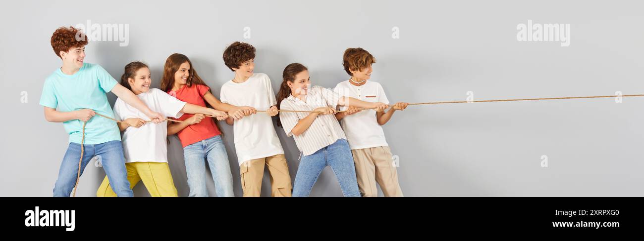 Friends Rope Pull Group of happy teenage friends playing tug of war, holding rope and ...