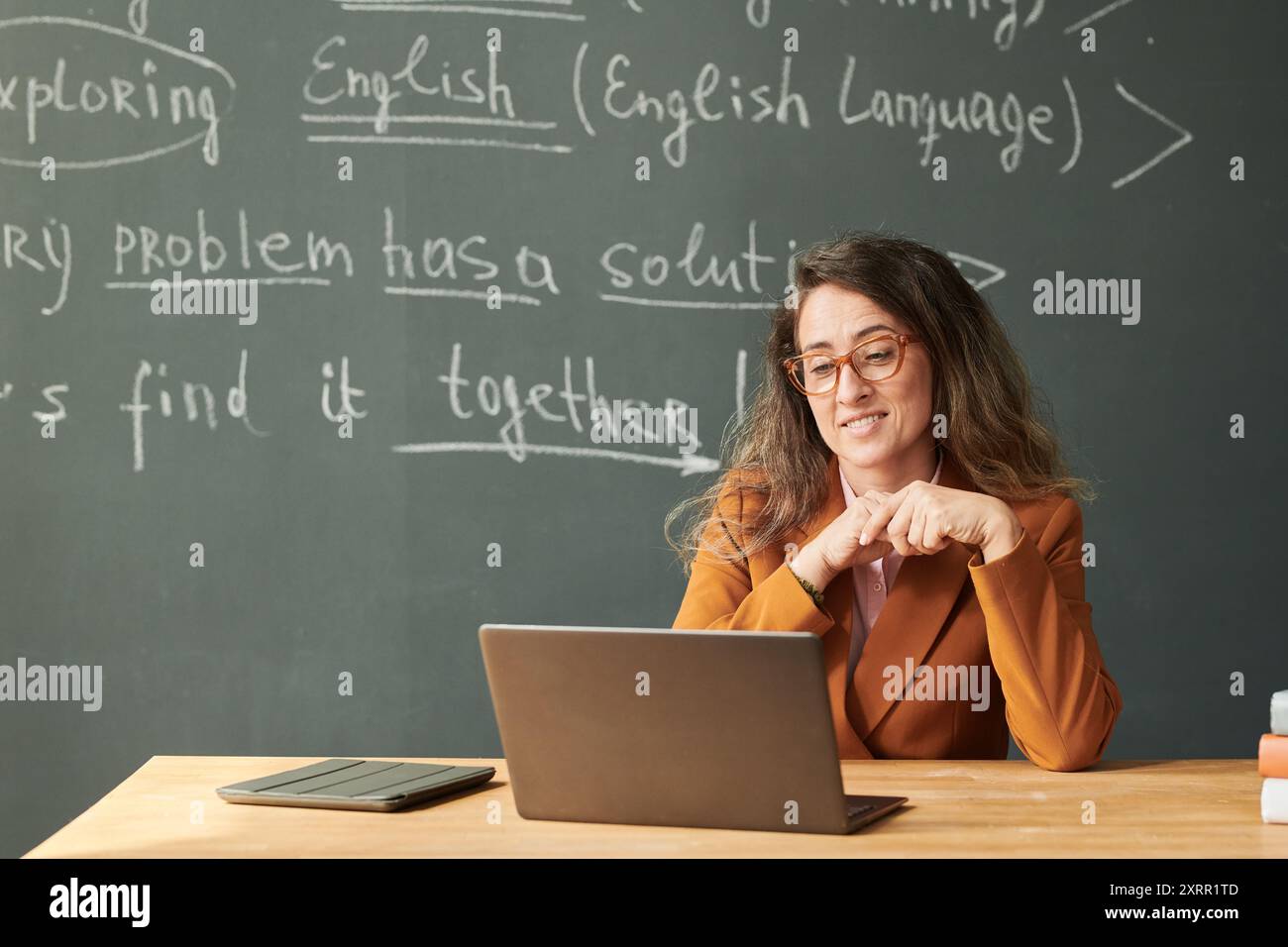 Teacher Looking at Laptop Screen in School Stock Photo - Alamy