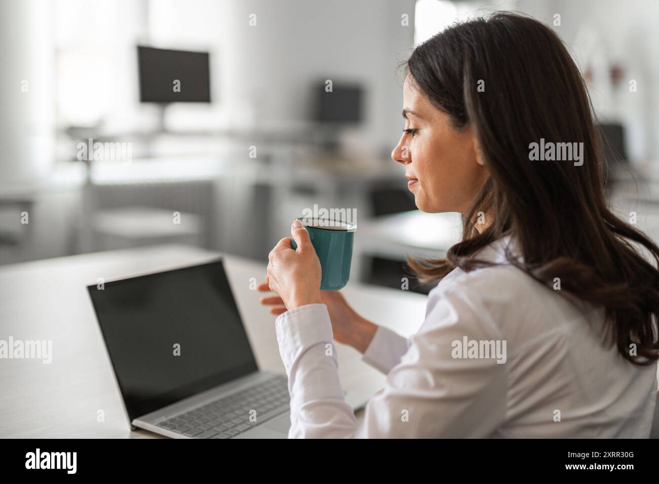 Young woman at her desk, copy space, mockup screen Stock Photo