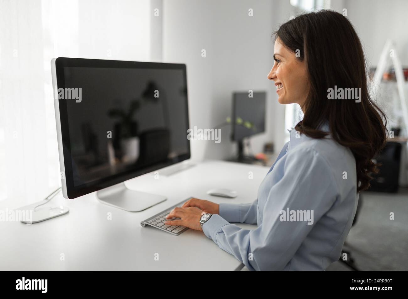 Business woman working on computer with mockup screen Stock Photo