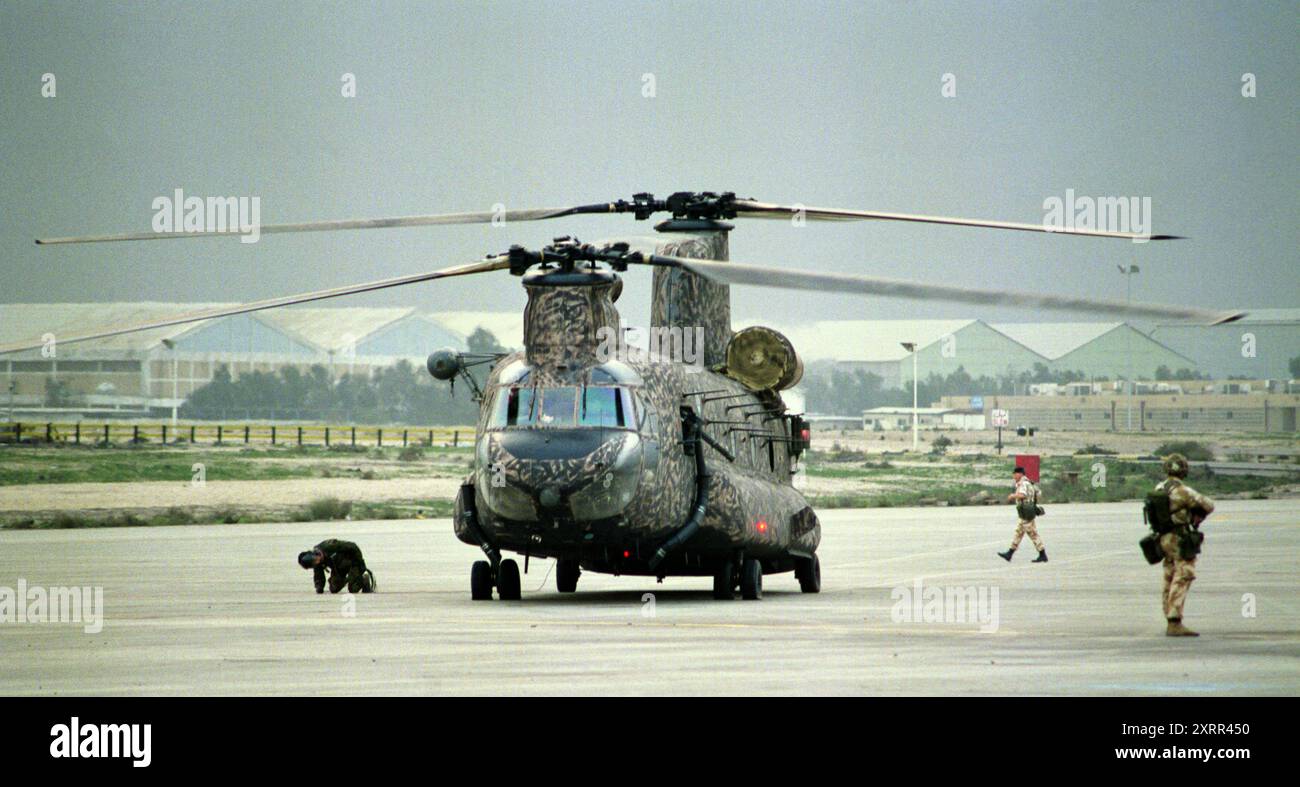 First Gulf War: 6th March 1991 A member of the crew checks damage to an RAF Boeing CH-47 Chinook helicopter, registration number ZA720/EP, at the International Airport in Kuwait City. Stock Photo