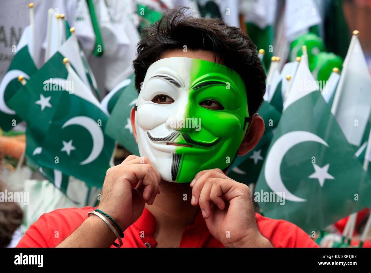 A boy wears a mask with the colors of the national flag in Peshawar ...