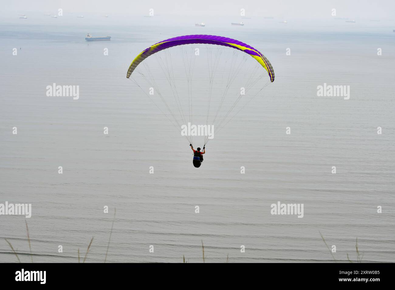 A paraglider flying over the bay of Santos, on the coast of the interior of the state of Sao Paulo, Brazil. Stock Photo