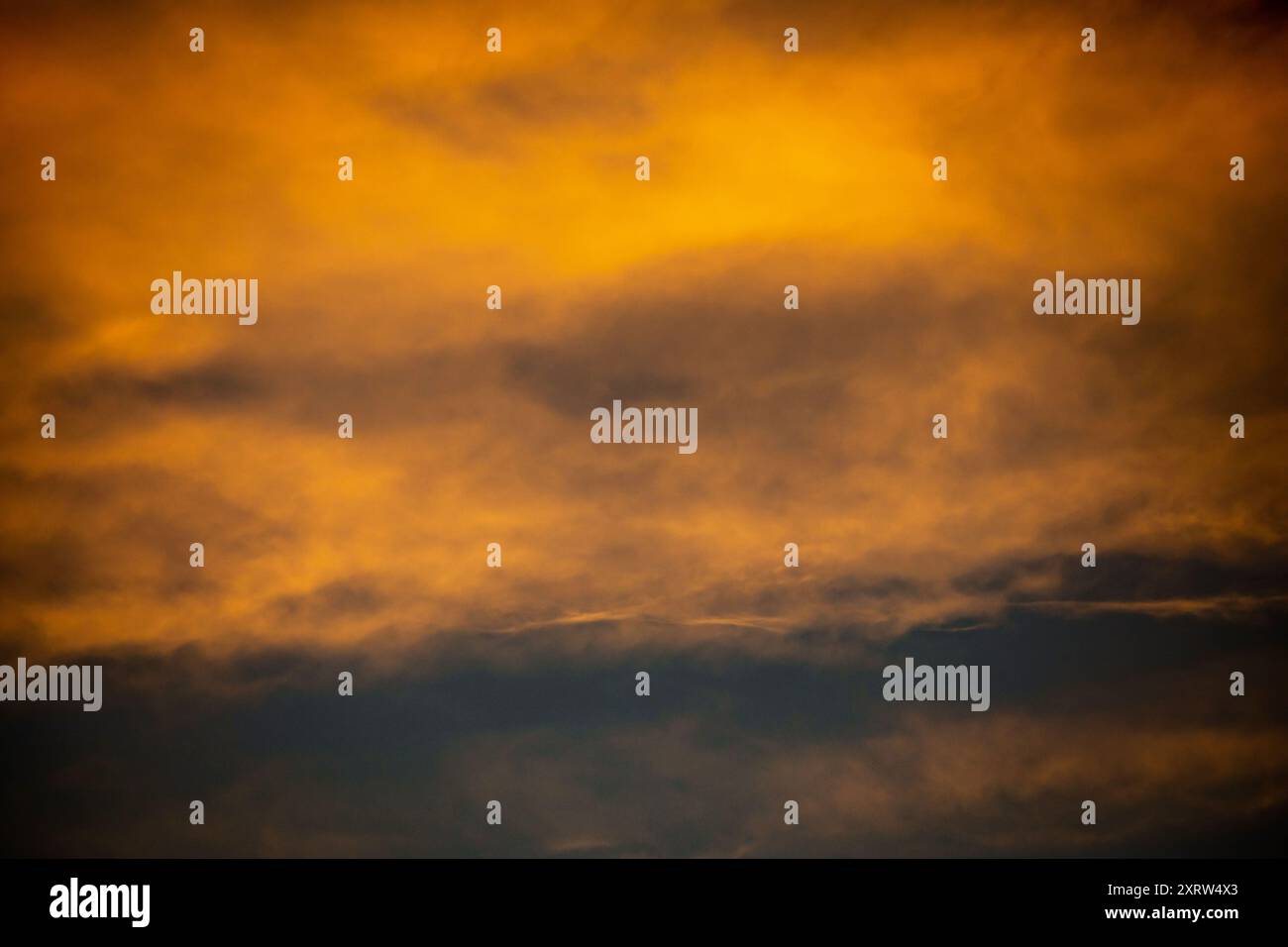 The setting sun creates an abstract pastel painting of sky and clouds. Stock Photo