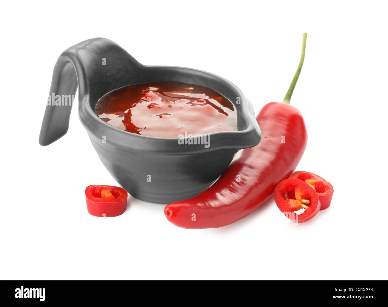 Hot chili sauce in gravy boat and pepper isolated on white Stock Photo