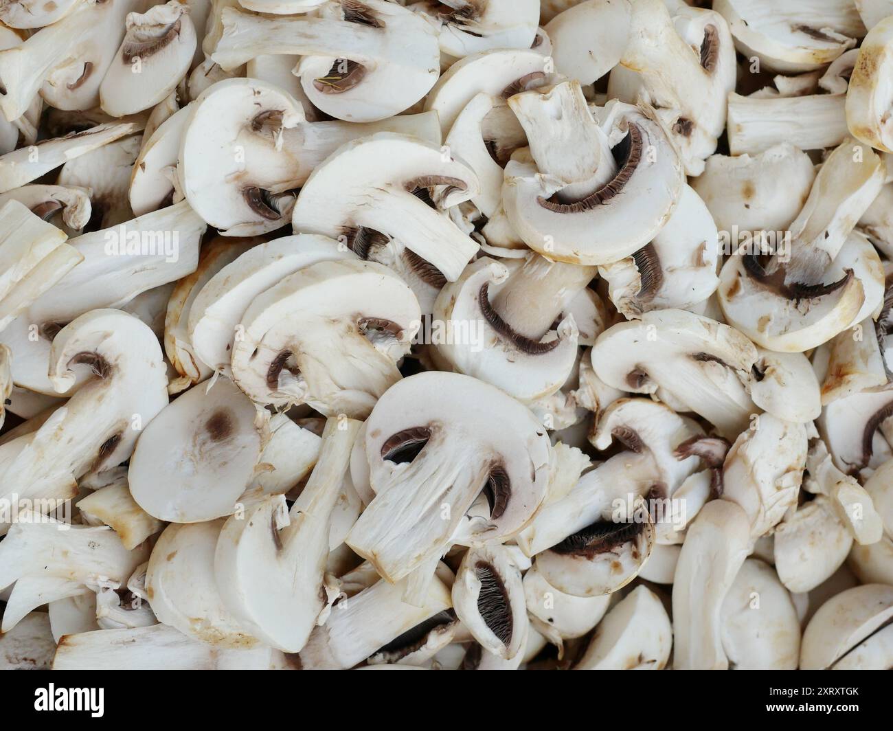 sliced champignons, perfect for salads, sautéing, or as pizza topping. Fresh, high-quality, and healthy, available in supermarkets. Stock Photo