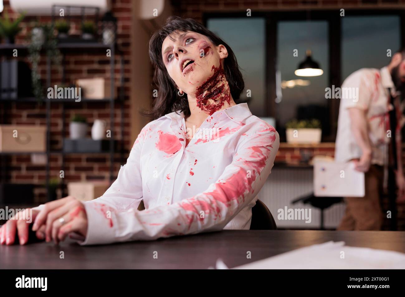 Woman dead on office desk chair after being worked to death, suffering from overwork and lack of sleep. Lifeless worker looking like undead zombie, victim of corporate rat race hustle culture Stock Photo