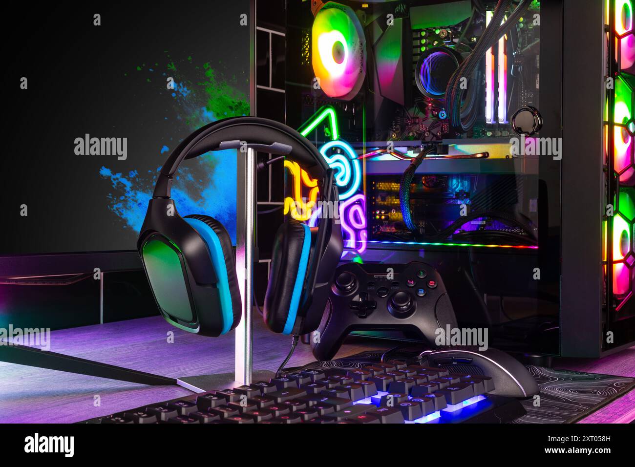 colorful gaming pc desk with bright raimbow led computer gamepad mouse keyboard and steering wheel. esports video games concept  background Stock Photo