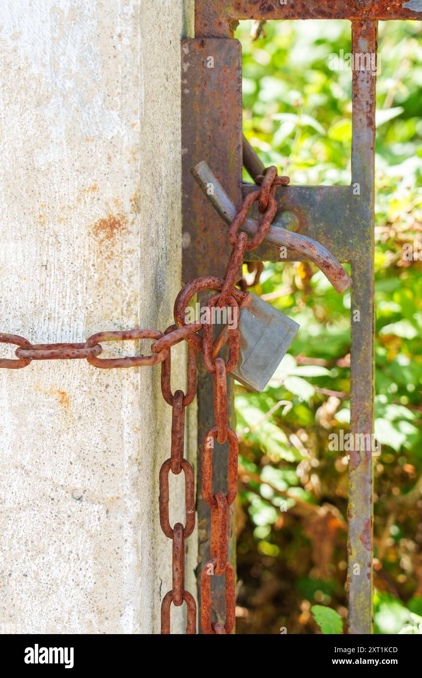 Closed padlock on a rusty iron chain close up Stock Photo