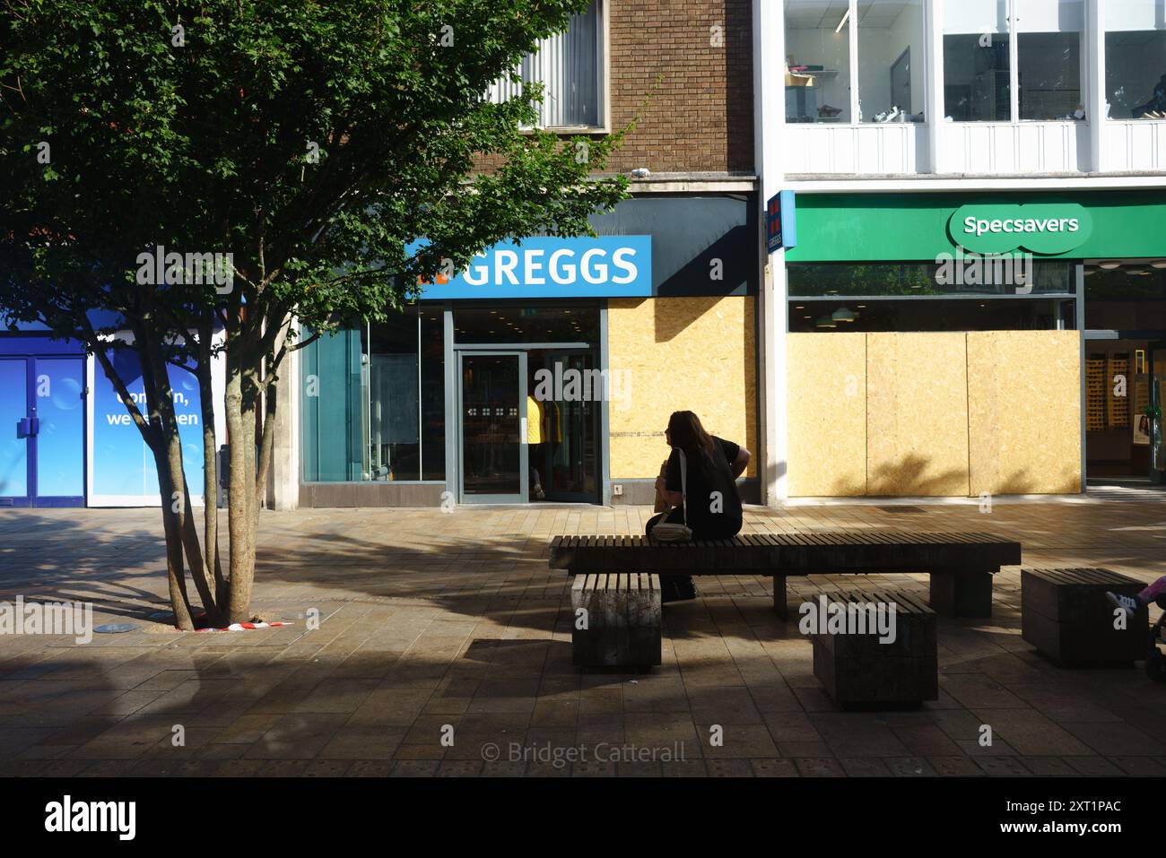 Hull, East Yorkshire, UK August 13th 2024. There have been 61 arrests with 22 charged, and three convicted on charges of violent disorder amidst riots in Hull 10 days ago. Others remain in custody, awaiting sentencing. Shops along Jameson St (directly opposite the railway station) and The Royal Hotel, believed to house refugees, had windows smashed and were looted. Shops remain boarded up. Shoezone which sustained most damage, is closed indefinitely.  Today, life carries on, with an increased police presence. PICTURED: Damage to Greggs and Specsavers. Bridget Catterall AlamyL Stock Photo